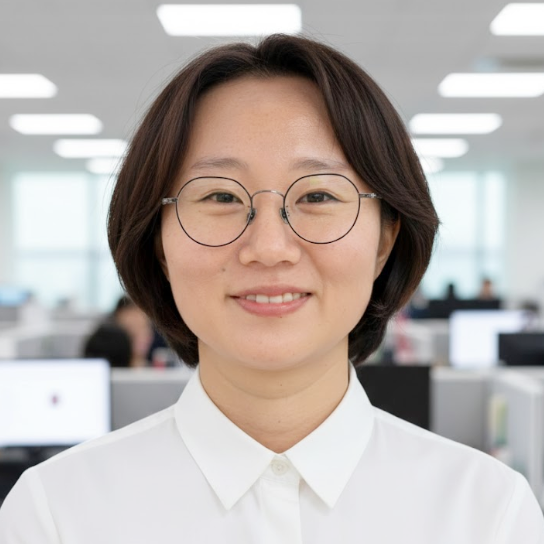 Professional portrait of Asian woman with shoulder-length hair wearing white blouse in modern office setting